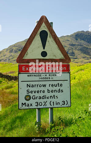 Extreme caution narrow route severe bend bends road warning sign signs Wrynose & Hardknott pass Lake District National Park Cumbria England UK Britain Stock Photo