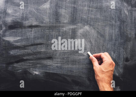 Teacher's hand is writing with chalk on blackboard, blank mock up copy space Stock Photo
