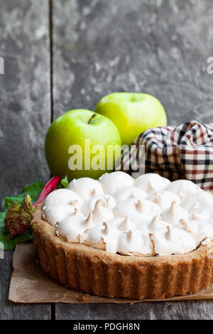 Tasty  meringue pie with rhubarb and apple on wooden table Stock Photo