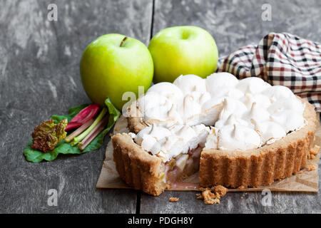Tasty  meringue pie with rhubarb and apple on wooden table Stock Photo