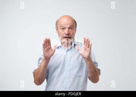 Studio shot of mature hispanic man against gray background. I can not belive what are you saying. Stock Photo