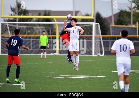 Player executing a header while absorbing contact from an opponent. USA. Stock Photo