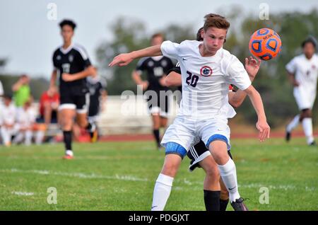 Player attempting to control an elevated ball deep in opposing territory. USA. Stock Photo