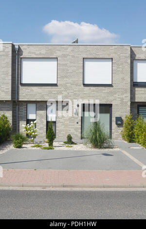Modern gray detached house, white windows with blinds pulled down Stock Photo