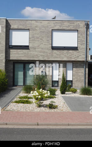 Modern gray detached house, white windows with blinds pulled down Stock Photo