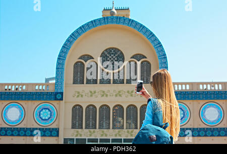 Woman taking mobile photo of the Central Souq (market) in Sharjah City, United Arab Emirates Stock Photo