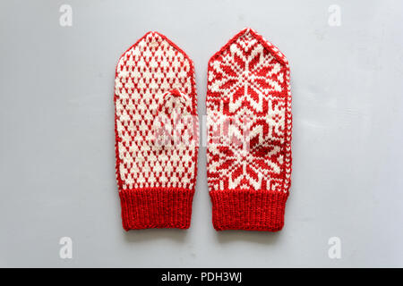 Knitted Norwegian jacquard gloves on gray wooden background. Top view. Flat lay Stock Photo