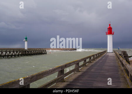 The green and red painted West and East lighthouses protecting each side of the harbour entrance at Trouville-sur-Mer, Normandy, France with a storm c Stock Photo