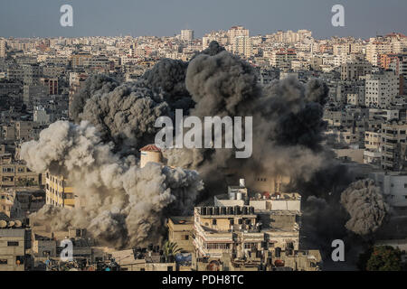 Gaza City, Gaza Strip. 09th Aug, 2018. Smoke rises from a multi-storey building after it was bombed by an Israeli aircraft in Gaza City, Gaza Strip, 09 August 2018. According to the Israeli Army, Israel has launched a wave of airstrikes on the Gaza strip in response to more than 180 rockets and mortars being fired into Israel, and gunfire earlier Wednesday that targeted civilian construction workers on the Gaza border. Credit: Emad Awad/dpa/Alamy Live News