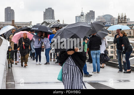 Bankside, London, UK. 9th August, 2018. Londoners get out their umbrellas and raincoats as rain and cooler weather replace the recent heatwave. Michael Heath/Alamy Live News Stock Photo