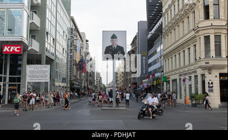 Berlin, Germany. 09th Aug, 2018. Numerous people are on the road at Checkpoint Charlie during the day. At the former border crossing point for diplomats in Berlin, American and Soviet tanks faced each other after the Wall was built 57 years ago. For many years, the free areas in the area have been used provisionally. Credit: Wolfgang Kumm/dpa/Alamy Live News Stock Photo