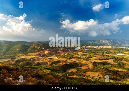 Panorama of the San Giorgio basin, with the town of Iglesias in the background and the ancient mines of Monteponi. Sky after a storm. Italy, Sardinia  Stock Photo