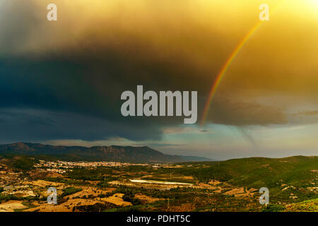 Panorama of the San Giorgio basin, with the town of Iglesias in the background and the ancient mines of Monteponi. Sky after a storm. Italy, Sardinia  Stock Photo