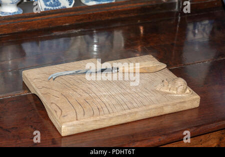 Antique cheese board and knife with a mouse carving in the righthand corner Stock Photo