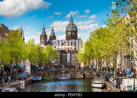 Amsterdam, Netherlands - April, 2018: St. Nicholas Basilica view. Spring day in Amsterdam with bridge, boats and bicycles Stock Photo