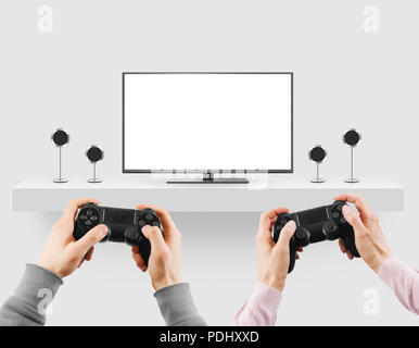 Man hold gamepad in hands in front of blank tv screen mock up playing game. Clear monitor mockup with gamer first person.   Stock Photo