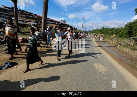 Rohingya refugees walking through road in front of the Balukhali Refugee Camp. Cox's Bazar, Bangladesh Stock Photo
