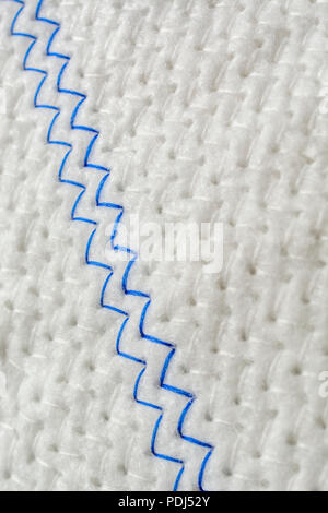 Close-up macro shot of zig-zag herringbone stitches of kitchen dishcloth. Stitched line, line of stitches, thread pattern. Stock Photo