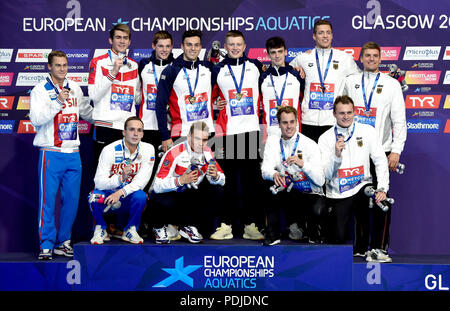 Team Great Britain (centre) celebrate winning Gold in the Men's 4 x 100m Medley Relay Final alongside Team Russia who took Silver (left) and Team Germany who took Bronze during day eight of the 2018 European Championships at the Tollcross International Swimming Centre, Glasgow. Stock Photo