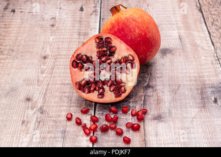 A cut open pomegranate fruit with seeds exposed Stock Photo