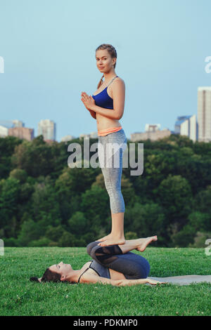 Premium Photo | Yoga together two young women are engaged in pair yoga  performing various asanas and meditating