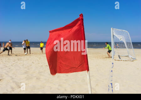 Red flag in a football field with gates on the sandy golden beach of the Baltic Sea Stock Photo