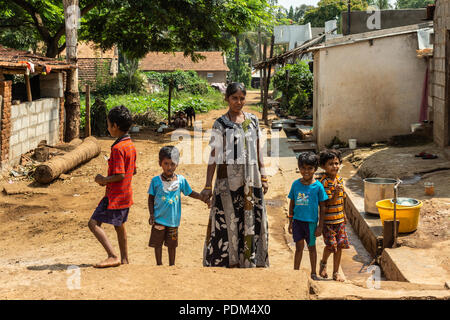 Nilavagilukaval, Karnataka, India - November 1, 2013: Mother with gray flowerly dress with four small children around her, set in village setting: dir Stock Photo