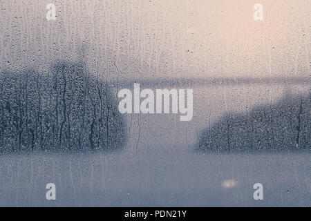 Rain leaves wet traces on the window. View of a bridge over a fjord in Norway. Stock Photo