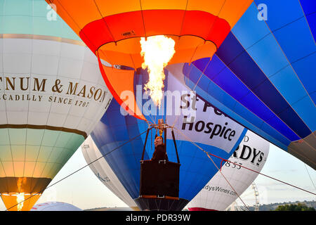 Balloon pilots burn during a ground tether flight after bad weather prevented flying at the Bristol International Balloon Fiesta at the Ashton Court Estate in Bristol. Stock Photo