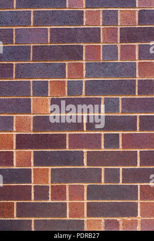 Vertical view of a brick wall background with a patchwork quilt design look in colors of blue, green brown, red and yellow Stock Photo