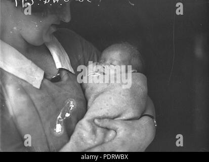 160 SLNSW 42686 Baby John Haywood in the arms of a nurse Stock Photo