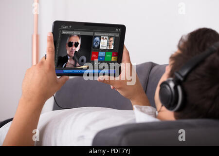 Man watching movie on website through digital tablet Stock Photo