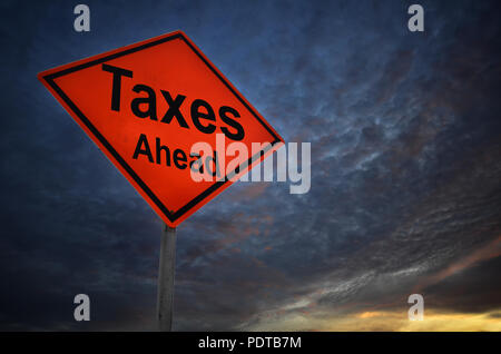 Taxes Ahead warning road sign with storm background Stock Photo