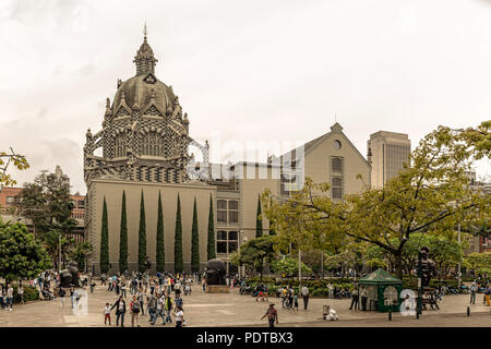 Medellin, Colombia - March 29, 2018: Tourists walking at Botero Plaza in Medellin, Colombia. At the background is the Palace of Culture Rafael Uribe   Stock Photo