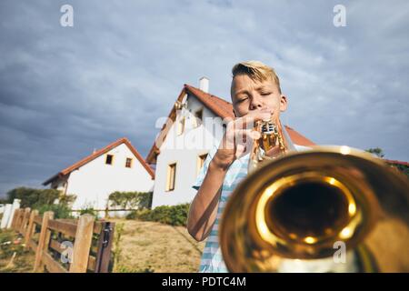 Young boy practicing playing trumpet in living room at home Stock Photo -  Alamy