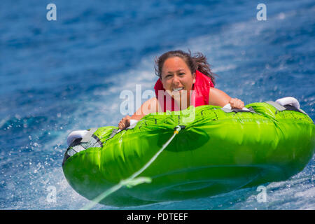 Young girl enjoys a ride on an inner tube on lake Tahoe Stock Photo
