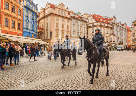 Prague, Czech Republic - January 15, 2015: Czech mounted police officers on horses in the Old Town Square and people walking in the street Stock Photo