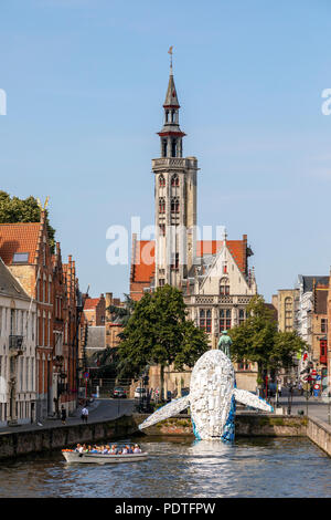 Tourists in a canal tour boat viewing the Bruges Plastic Whale sculpture made from discarded plastic containers and waste washed up from the sea, Stock Photo