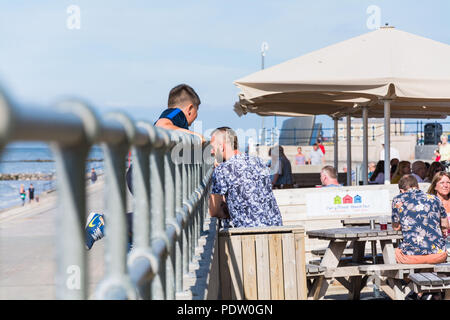 People enjoying themselves during the summer heatwave (2018) at Central Beach, Prestatyn, North Wales, UK. Stock Photo