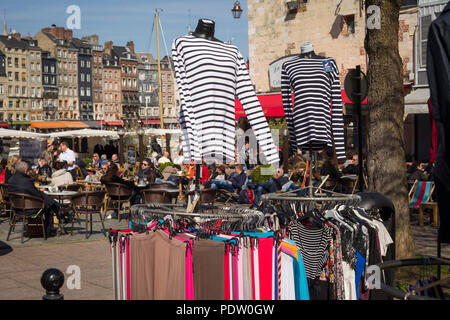 Clothes hanging for sale in a market stall at the Saturday market in Honfleur, Normandy, France Stock Photo