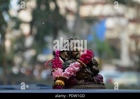 Hindu elephant god Ganesha bronze idol on a car dashboard Stock Photo