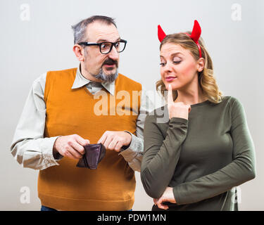 Nerdy man is uncertain,he is thinking does his wife love more him or his money. Stock Photo