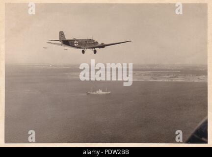 Image from the photo album of Oberfeldwebel Karl Gendner of 1. Staffel, Kampfgeschwader 40: Air to air photograph of Junkers Ju 52/3m transport aircraft of I./KGzbV 1 flying towards the Danish Coast in May 1940. The aircraft in the foreground is coded 1Z+GK and is a 2. Staffel aircraft. Of interest is the oversize swastika on the tail. Stock Photo