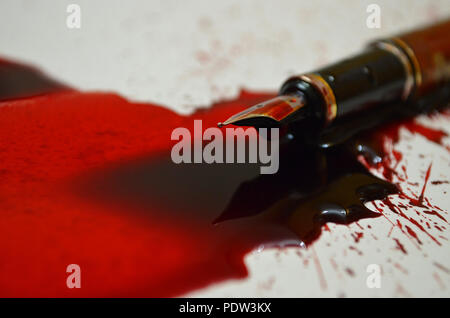 Pen and spilled red ink depicting that a pen is mightier than a sword Stock Photo