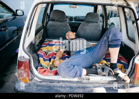 Man sleeping in a car in Bishkek Stock Photo