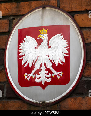 POLAND, KRAKOW - March 20, 2018: Coat of arms of Poland. The coat of arms of Poland is a white, crowned eagle with a golden beak and talons, on a red brick background Stock Photo