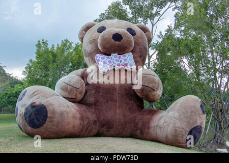 The giant plush teddy bear sitting on a green meadow in the garden Stock Photo Alamy