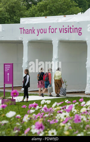 Home time - people with shopping bags, walking towards exit, passing display of flowering cosmos - RHS Chatsworth Flower Show, Derbyshire, England, UK Stock Photo