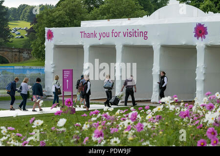 Home time - people walking towards exit, passing beautiful display of flowering cosmos - RHS Chatsworth Flower Show, Derbyshire, England, UK. Stock Photo