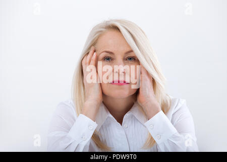 Woman Headache isolated. Menopause. Middle aged woman looking at the camera Stock Photo